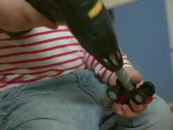 Little Boy Repairing A Toy Vehicle Stock Footage