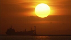 A giant sun glows above a silhouetted ship on Manila Bay. Stock Footage