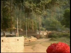 MS pan left from men to sculptures in road, shrines, Rajasthan, India Stock Footage