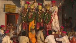 A crowd of spectators tosses flower petals over costumed performers that stand on a dais during Diwali. Stock Footage