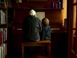 Slow push in on grandmother and grandson having fun, playing the piano. Stock Footage