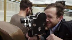 Young man cruising in classic Bronco with friends shoots on vintage film camera Stock Footage