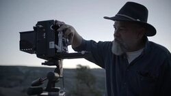 Middle-Aged Caucasian Male Outdoor Photographer Adjusting Camera Stock Footage