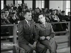 1945: MILITARY TRIBUNAL: FIRST WITNESS: MS Joseph Pusch & interpreter speaking about victims, Pusch standing up to demonstrate, interpreter translating German-English. WS Audience in courtroom. VS U.S. Military Commission, Pusch speaking. Instructional Video