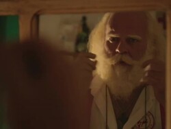 M/S Santa looking at a mirror and stroking his moustache and beard Stock Footage