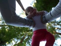 A infant girl in the arms of her mother with Redwood trees behind them. Stock Footage