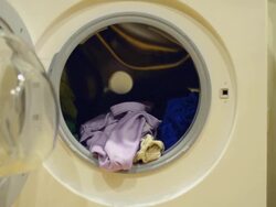 put their clothes out of Washing machine under low light Stock Footage