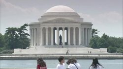 Tourists walk past the Thomas Jefferson Memorial on the other side of the Potomac River. Stock Footage