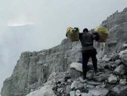 WS Miner climbing Ijen volcano crater carrying sulfur / Ijen, Java, Indonesia Stock Footage