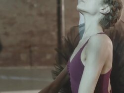 Ballerina stretching at ballet bar in dance studio Stock Footage