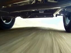 Camera under jeep looking at wheels and axel on dirt road Stock Footage