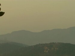 Long Shot pan-left - Small statues decorate the roof of a pagoda against a hazy sky./Beijing, China Stock Footage