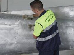 MS aircraft mechanic sanding down airplane stripped back to aluminum hull, RED R3D 4K Stock Footage
