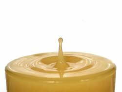 CU SLO MO Drop of orange juice falling into glass against white background / Vieux Pont, Normandy, France Stock Footage