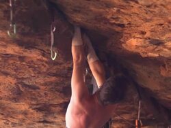 MS PAN Shot of male climber climbing rock upside down / Moab, Utah, United States Stock Footage