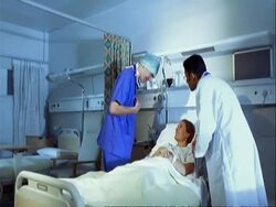 MS track to medics talking to patient in hospital bed Stock Footage