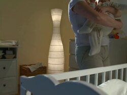 HD CRANE: Mother Putting Baby To Bed Stock Footage