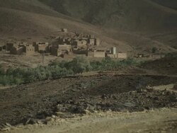 A small settlement stands within a harsh Moroccan terrain. Stock Footage