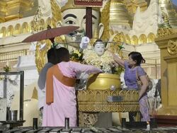 MS Shot of women and nun pouring water on Buddha likeness at shrine in shwedagon pagoda / Yangon, Yangon Division, Myanmar Stock Footage