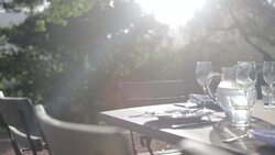 Sunbeam on table with luxury place settings in backyard Stock Footage