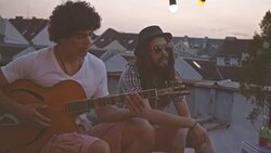 Playing guitar with friend on rooftop party Stock Footage