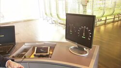 A technician operates a computer that displays speedometer data. Stock Footage