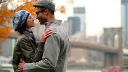 Young man pulls girlfriend in for kiss in autumn park Stock Footage