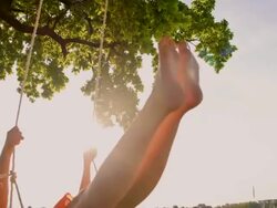 SLO MO Cheerful girl swinging on a tree swing Stock Footage