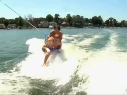 SLO MO young men riding wake board behind boat Stock Footage