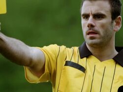 MS TD TU referee blowing whistle and showing yellow card on field to professional soccer player arguing call Stock Footage