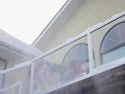 Mother and daughter shoveling snow off house deck Stock Footage