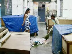MS SLO MO Shot of woman sweeping market floor and young woman in dress passing by / Luang Prabang, Laos Stock Footage