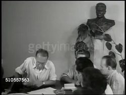 1948: YUGOSLAVIA WORKER'S COUNCIL: INT WS Yugoslavian members of worker's council in meeting. VS Men around table talking, listening. CU Award pennant. VS Man talking to workers, worker passing pennant to another man. Five-Year Plan Instructional Video