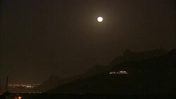 A full moon glows over a glittering city. Stock Footage