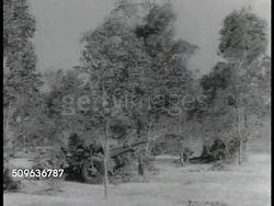 1941: SOLDIERS INTO POSITION. Australian soldiers pulling artillery gun into position, soldiers using field radio FG. Artillery gun firing. Small tanks (3, open top, headlights, gun like armored car w/ treads) moving on field & out of frame (R). WWII Instructional Video