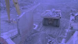 A dump truck  backs up with a load of rocks and gravel at a quarry. Stock Footage