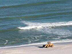 Excavator moves along beach after oil spill Stock Footage