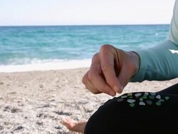 Detail of woman sifting through sandy beach, finding gems Stock Footage