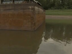 Medium pan-left - The Mississippi River flows around a large dredger along the riverbank / Mississippi River Stock Footage