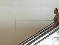  MS Businessman riding down escalator in building / Seattle, Washington, United States Stock Footage
