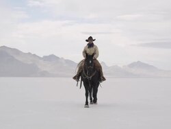Cowboy riding horse on salt flats. Stock Footage