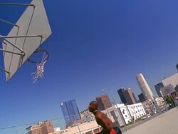 CANTED wide shot PAN Black man doing cartwheel with basketball + dunking basketball on outdoor court Stock Footage