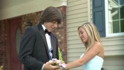 CU, Young man putting corsage on girl's (16-17) wrist in front of house, Edison, New Jersey, USA Stock Footage