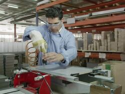 MS worker screwing metal rails onto piece of furniture in furniture factory Stock Footage