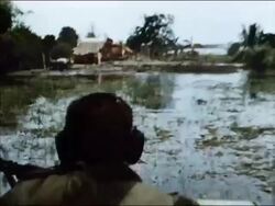 1964 medium shot point of view over the shoulder of soldier piloting boat over marshland / Vietnam Stock Footage