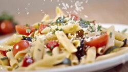 SLO MO Sprinkling parmesan over pasta with fresh vegetables Stock Footage