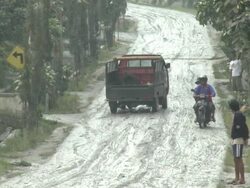 Small truck struggles up hill coated in volcanic ash mud, helper, after Merapi volcano eruption; Indonesia. 7 November 2010 / AUDIO Stock Footage