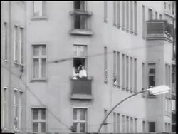 B/W 1961 people in windows of East Berlin window waving handkerchiefs / Cold War / Germany Stock Footage