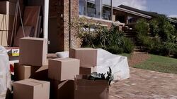 Moving truck and cardboard boxes in driveway Stock Footage