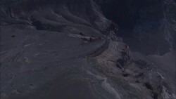 A volcanologist stands on a ridge overlooking a crater lake. Stock Footage